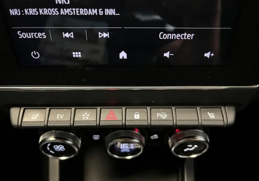 Gros plan sur la console centrale du Renault Arkana blanc, avec commandes climatisation et écran tactile visible.