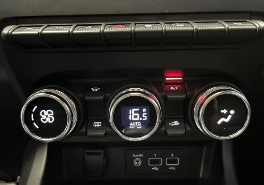 Gros plan sur les commandes de climatisation digitale du Renault Arkana R.S. Line 2022 avec boutons ronds chromés et affichage à 16,5°C.