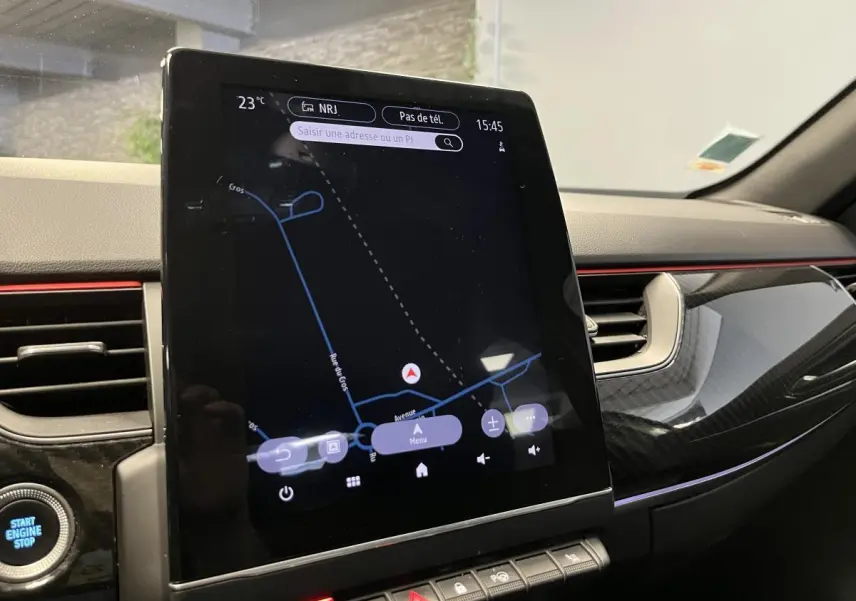 Vue rapprochée de la console centrale du Renault Arkana blanc, écran tactile Easy Link avec finition carbone et bandeau rouge.