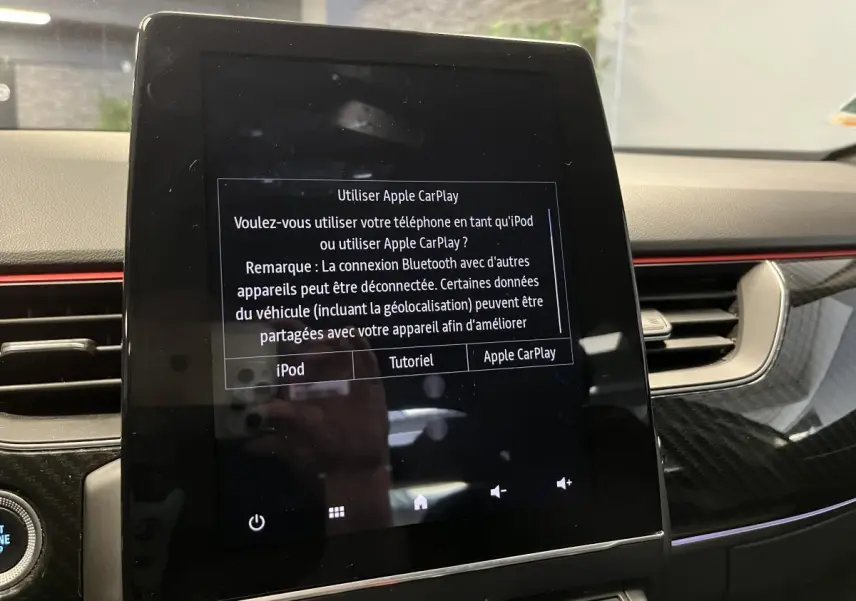 Écran tactile central affichant l'interface Apple CarPlay dans l'habitacle du Renault Arkana R.S. Line 2022.