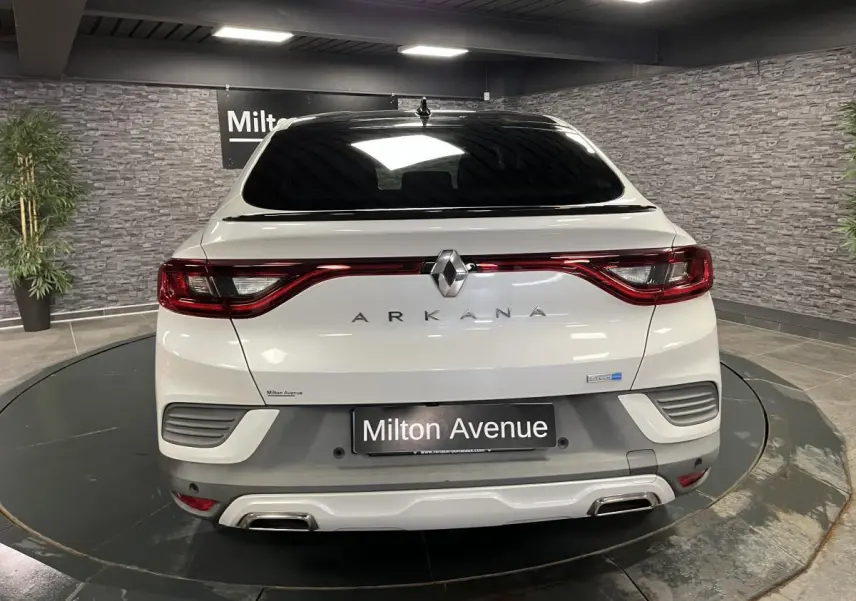 Vue arrière d'un Renault Arkana blanc perle avec toit noir brillant et double sortie d'échappement intégrée au bouclier.