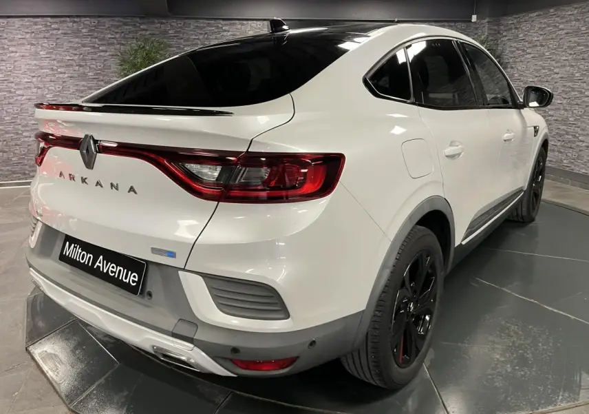 Vue 3/4 arrière droite du Renault Arkana blanc perle avec toit noir brillant et jantes noires R.S. Line.