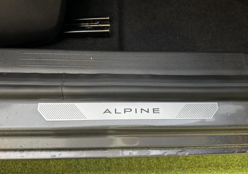 Gros plan sur la plaque de seuil de porte "ALPINE" du Renault Clio gris schiste, côté intérieur au sol.