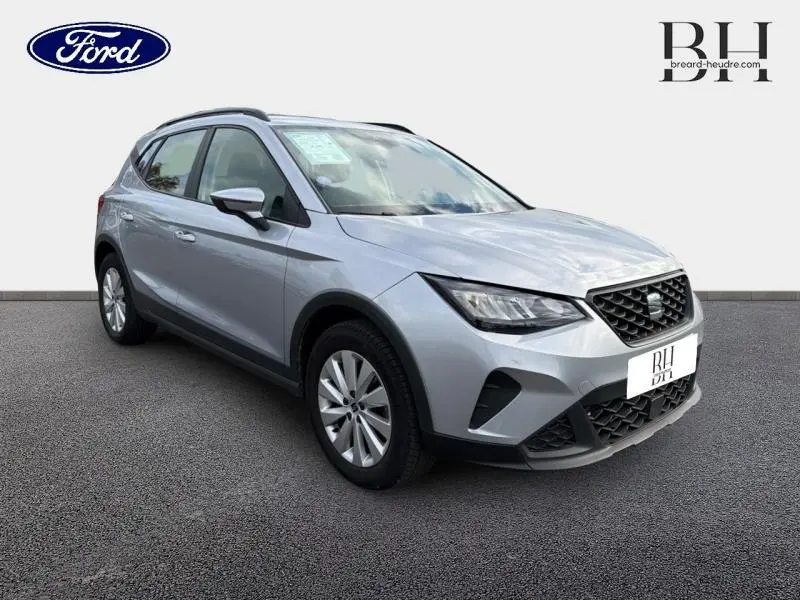 SEAT Arona gris urbain métal vue 3/4 avant droit, mettant en valeur sa calandre et ses jantes alu.