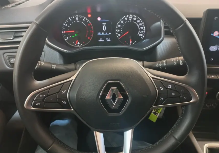 Vue rapprochée du volant cuir synthétique noir de la Renault Clio Business 2021 avec commandes multifonctions et tableau de bord digital.