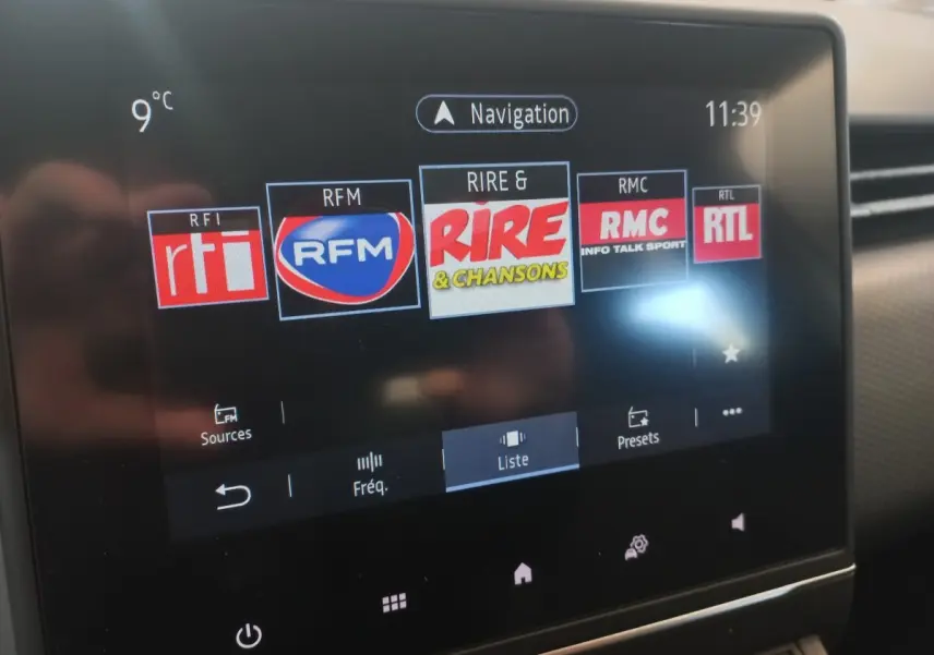Écran tactile central de la Renault Clio Business blanc, affichant les stations radio FM avec température extérieure à 9°C.