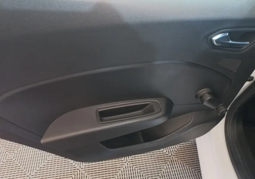 Vue intérieure côté gauche de la porte avant d'une Renault Clio Business blanche avec manivelle de vitre manuelle.