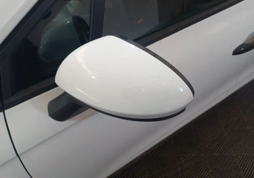 Rétroviseur droit blanc de Renault Clio Business 2021 avec gouttes d'eau, vue rapprochée côté conducteur.