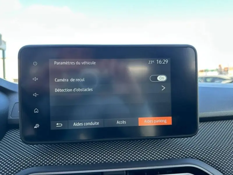 Écran tactile central du Dacia Jogger 2025 affichant les paramètres du véhicule, avec options caméra de recul et détection d'obstacles.