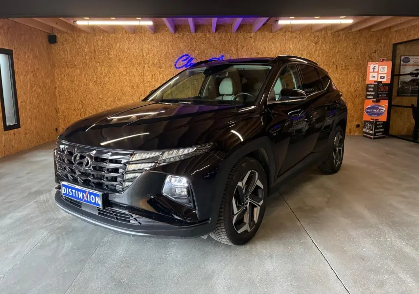 Hyundai Tucson noir 2022 en 3/4 avant droit, avec calandre distinctive et jantes modernes, dans un showroom intérieur.