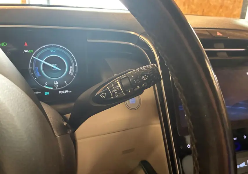Vue rapprochée du tableau de bord et du commodo d’essuie-glace d’un Hyundai Tucson hybride 2022 avec intérieur beige.