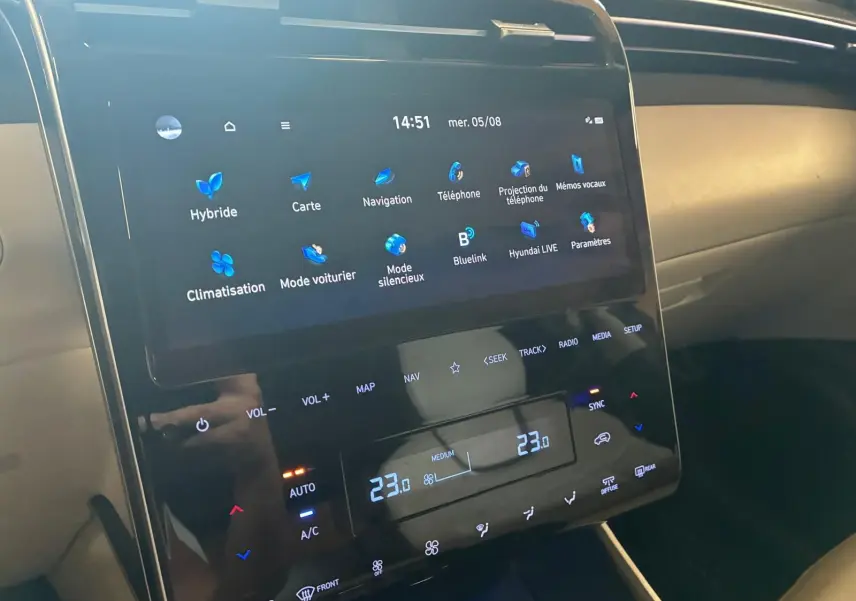 Vue rapprochée de l'écran tactile central du Hyundai Tucson noir 2022, affichant la climatisation et la navigation.