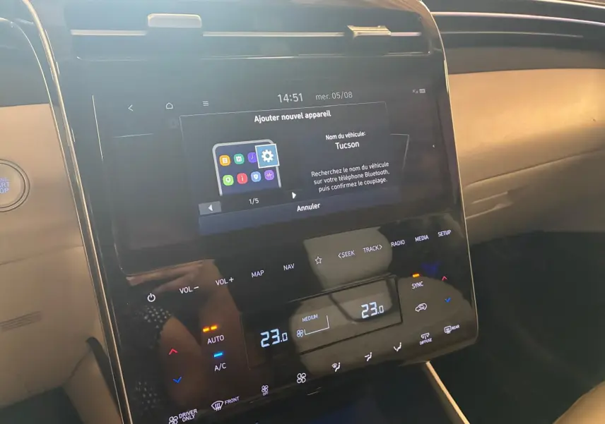 Vue rapprochée de la console centrale tactile du Hyundai Tucson noir 2022, affichant les réglages de climatisation et Bluetooth.