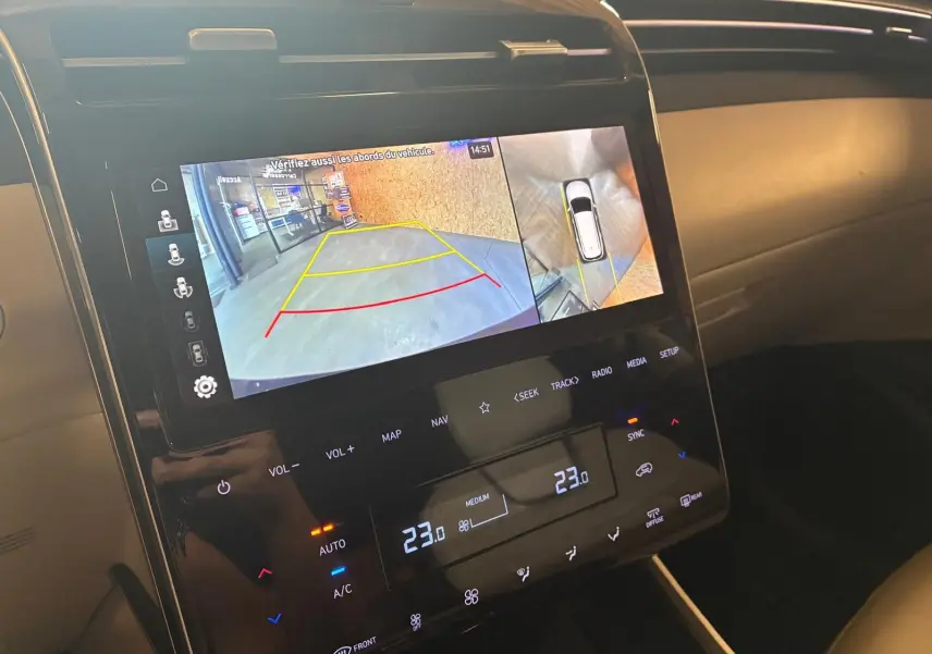 Écran central du Hyundai Tucson 2022 noir montrant la caméra de recul et les commandes de climatisation digitale.