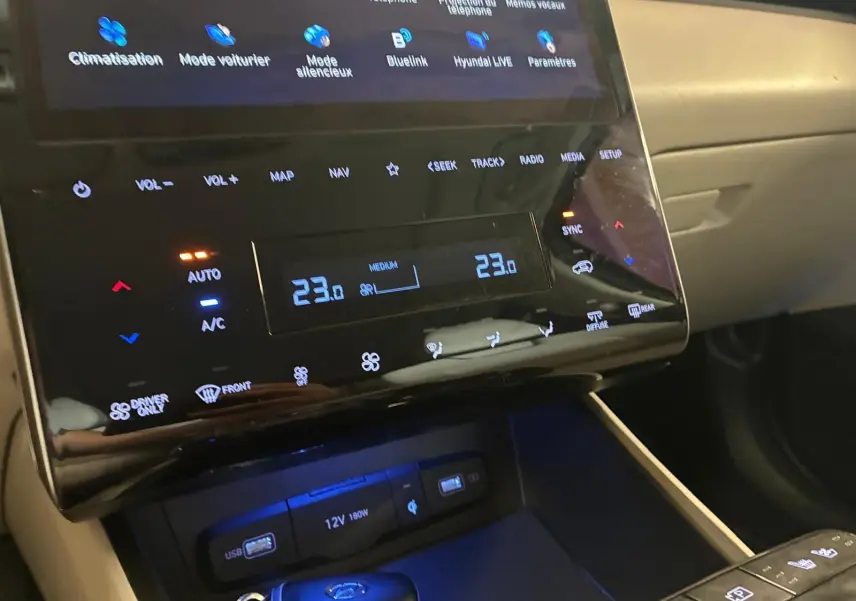 Détail de la console centrale du Hyundai Tucson 2022 noir, avec écran tactile et commandes de climatisation numériques.