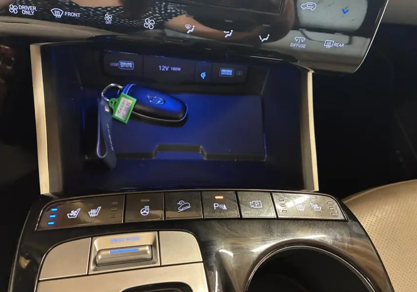Gros plan sur la console centrale noire du Hyundai Tucson 2022, avec clés, commandes chauffantes et boutons multifonctions.