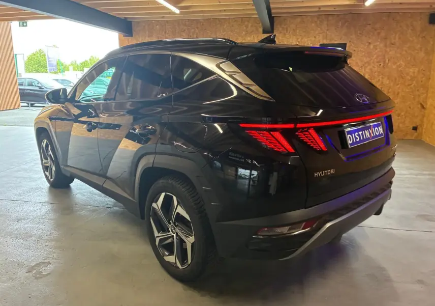 Vue 3/4 arrière droite du Hyundai Tucson noir 2022 hybride, avec feux arrière LED et jantes alliage distinctives.