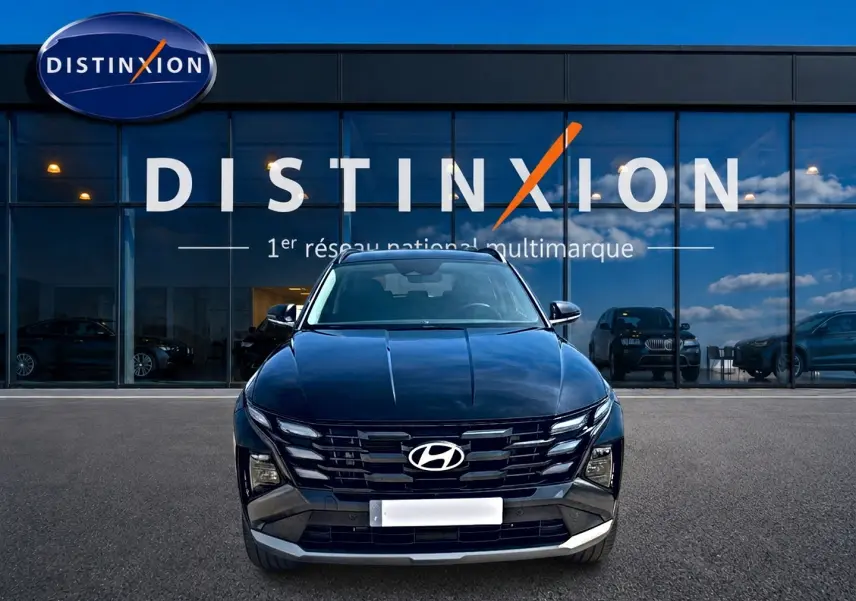 Vue de face du Hyundai Tucson noir 2026 avec calandre distinctive et logo Hyundai visible devant un showroom Distinxion.