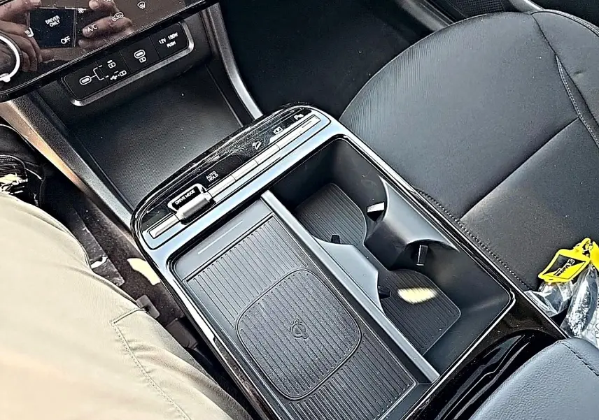 Vue plongeante sur la console centrale noire du Hyundai Tucson 2026, avec porte-gobelets et commandes tactiles.