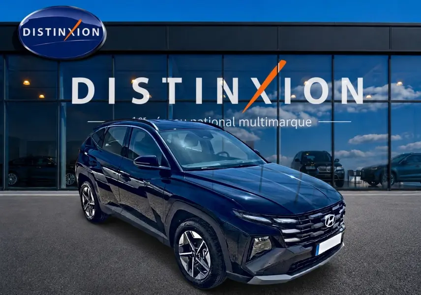 Vue 3/4 avant du Hyundai Tucson noir 2026 devant une vitrine avec logo Distinxion, jantes alu et phares LED visibles.