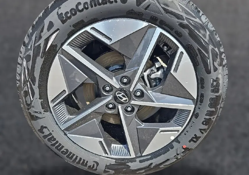 Gros plan sur une jante alu 18 pouces bicolore avec logo Hyundai au centre, montée sur pneu Continental EcoContact 6.