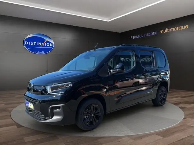 Vue 3/4 avant gauche d'un Citroën Berlingo noir 2025 avec jantes noires et caméra de recul en showroom.