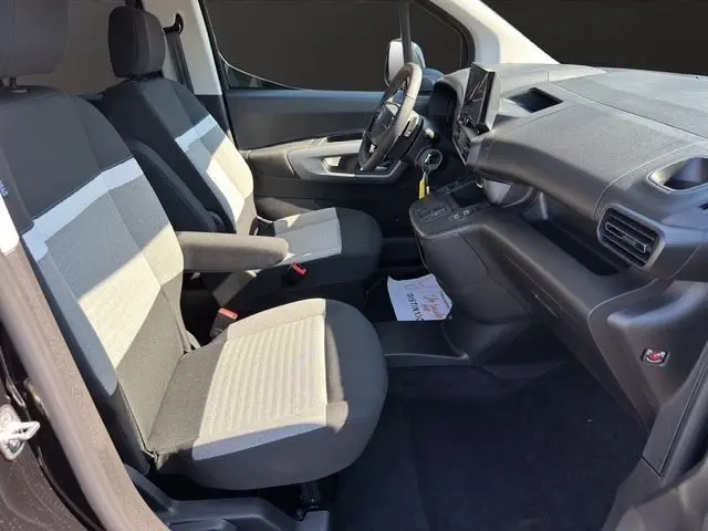 Vue intérieure avant du Citroën Berlingo N1 BlueHDi 130 2025, tableau de bord noir avec écran central tactile et volant multifonction.