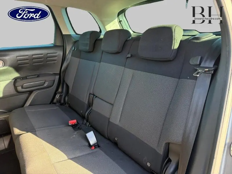 Vue intérieure sur la banquette arrière en tissu gris d'une Citroën C3 Aircross 2019, côté droit, avec ceintures et appuie-têtes visibles