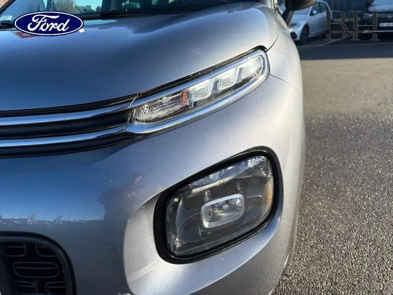 Gros plan sur le phare avant droit gris acier d'une Citroën C3 Aircross 2019 avec feux LED et calandre fine.