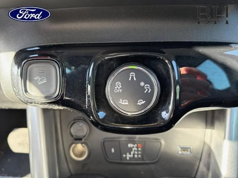 Gros plan sur le bouton de sélection de modes de conduite dans l'habitacle d'une Citroën C3 Aircross gris acier.