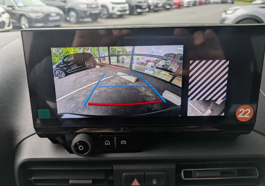 Écran intérieur du Citroën Berlingo blanc 2025 montrant la caméra de recul avec guidage de trajectoire en bleu et rouge.