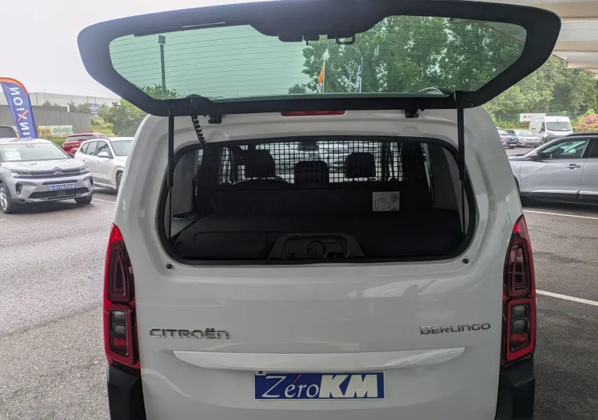Vue arrière du Citroën Berlingo blanc 2025 avec hayon ouvert et séparation intérieure visible.