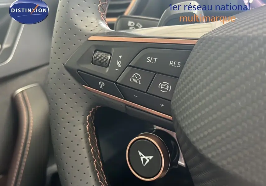 Gros plan sur le volant perforé noir de la CUPRA Formentor 1.5 eTSI avec commandes intégrées et finition cuivre.