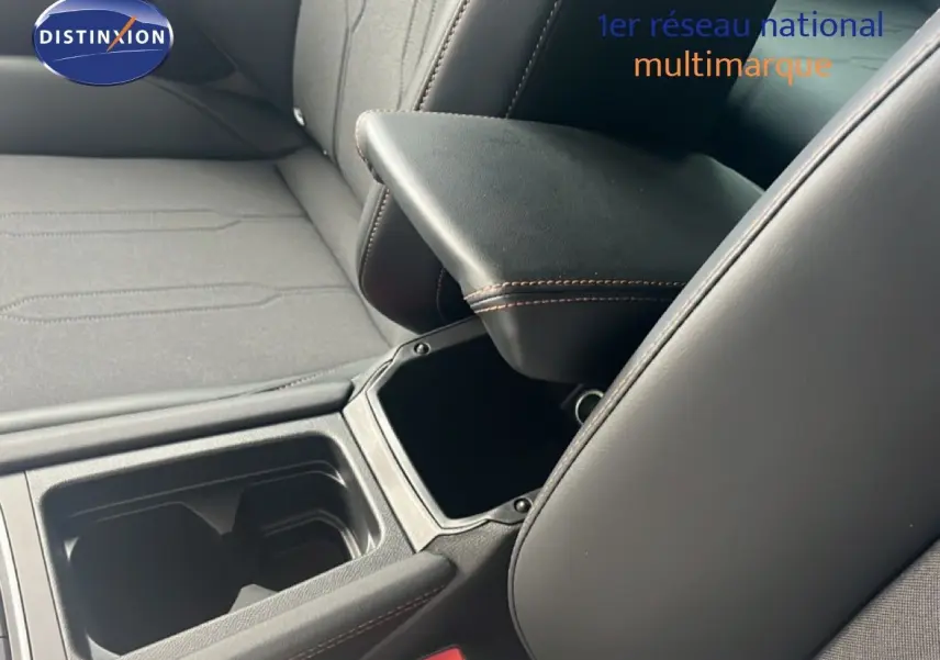 Détail intérieur montrant l'accoudoir central noir avec surpiqûres marron et les sièges tissu cuir du CUPRA Formentor bleu Fjord 2026.
