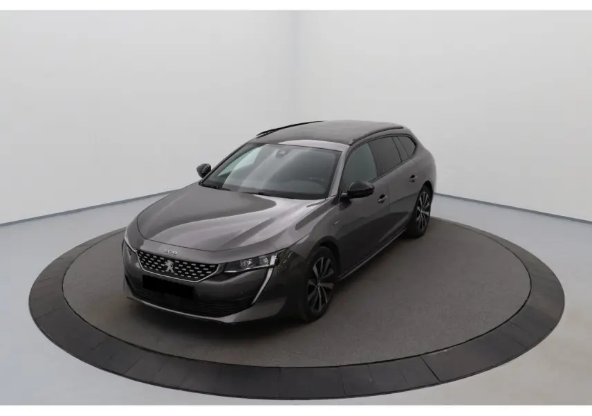 Peugeot 508 SW gris Platinium vue 3/4 avant droit, avec jantes bi-ton et toit panoramique noir brillant.