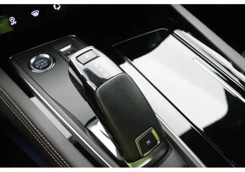 Le levier de boîte automatique noir et brillant de la Peugeot 508 SW GT Line vu en gros plan sur la console centrale.