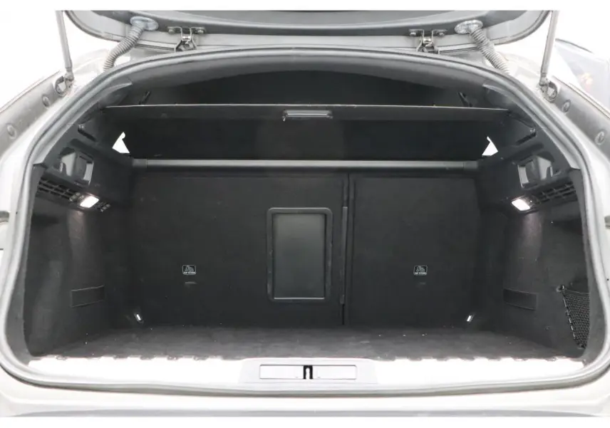 Coffre ouvert de la Peugeot 508 SW gris Platinium, vue intérieure arrière montrant l'espace de chargement noir.