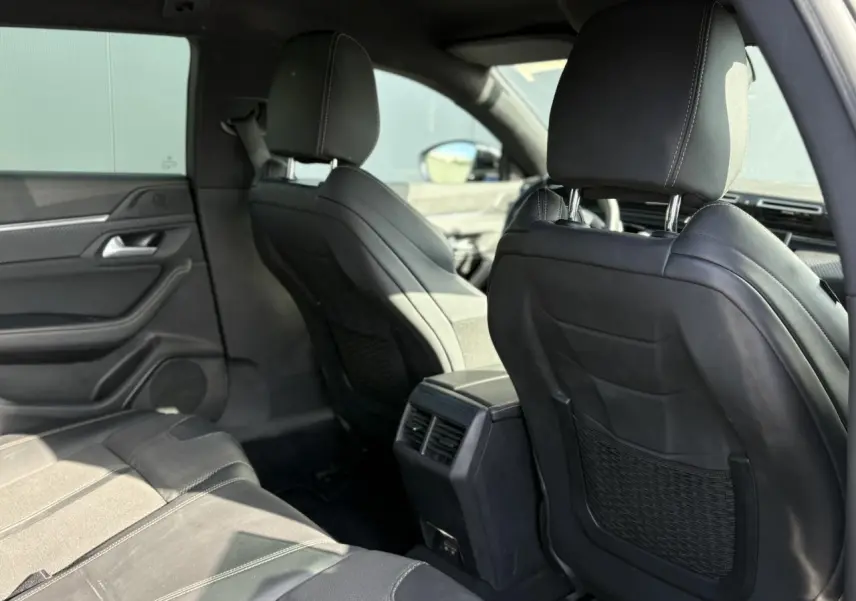 Vue arrière de l'habitacle noir de la Peugeot 508 SW GT Line 2020, mettant en valeur les sièges avant et aérateurs centraux.