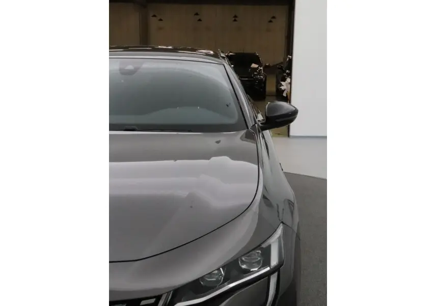 Vue avant droite d'une Peugeot 508 SW gris Platinium avec phares Full LED et rétroviseur noir brillant.