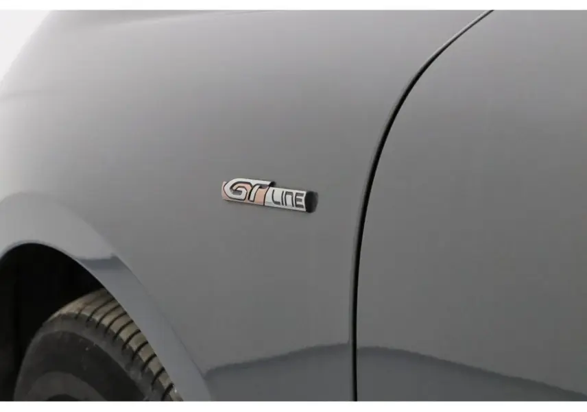 Gros plan sur l'aile avant gauche gris Platinium d'une Peugeot 508 SW avec badge GT Line visible.