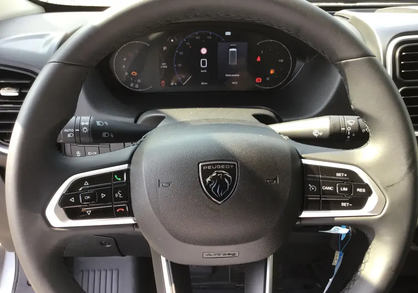 Vue rapprochée du volant Peugeot du Boxer Fourgon 2025 avec commandes intégrées et tableau de bord numérique.