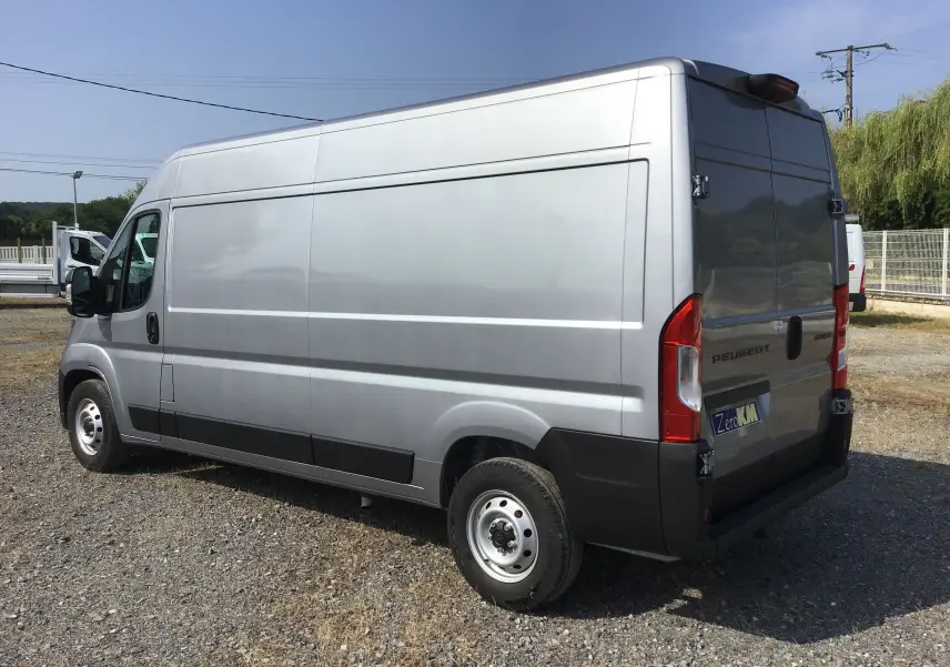 Vue 3/4 arrière droit d'un Peugeot Boxer Fourgon gris Artense, avec portes arrière fermées et jantes acier simples.