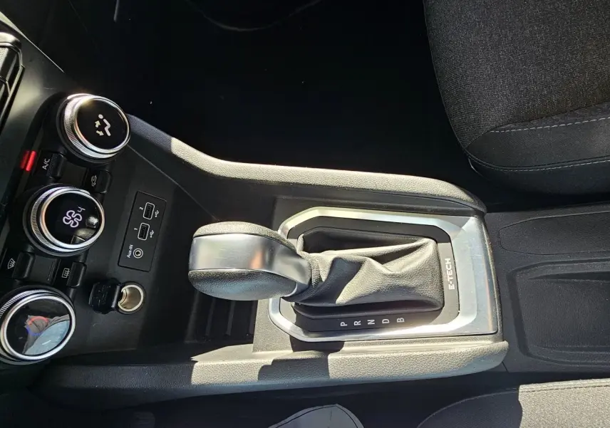 Le levier de vitesses automatique E-TECH de la Renault Clio blanche, avec commandes de climatisation et ports USB visibles.