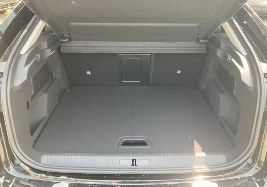 Coffre ouvert d'une Citroën C4 noir perla, montrant un espace de chargement propre et bien fini.