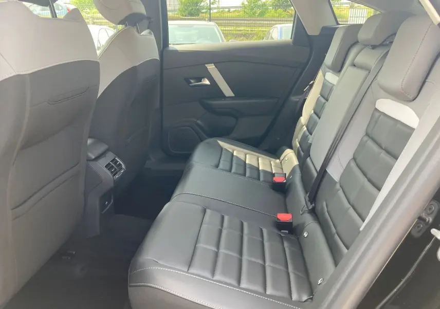 Vue intérieure arrière droite de la Citroën C4 2025, sièges cuir TEP noir et gris avec surpiqûres blanches.