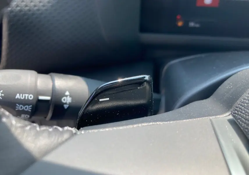 Gros plan sur la palette de changement de vitesse noire côté droit du volant d'une Citroën C4 hybride 2025.