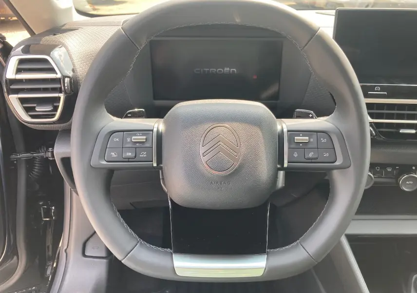 Volant cuir noir de la Citroën C4 Facelift Hybrid 145 e-DSC6 Max avec commandes intégrées et tableau de bord numérique.