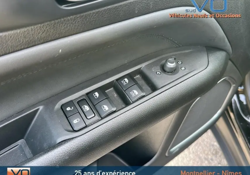 Gros plan sur les commandes de vitres et rétroviseurs sur la porte côté conducteur du Jeep Compass noir 2024.