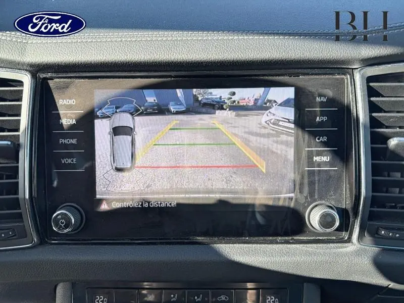 Écran tactile montrant la caméra de recul d'un Skoda Kodiaq noir Magic Nacré avec guidage de trajectoire coloré.