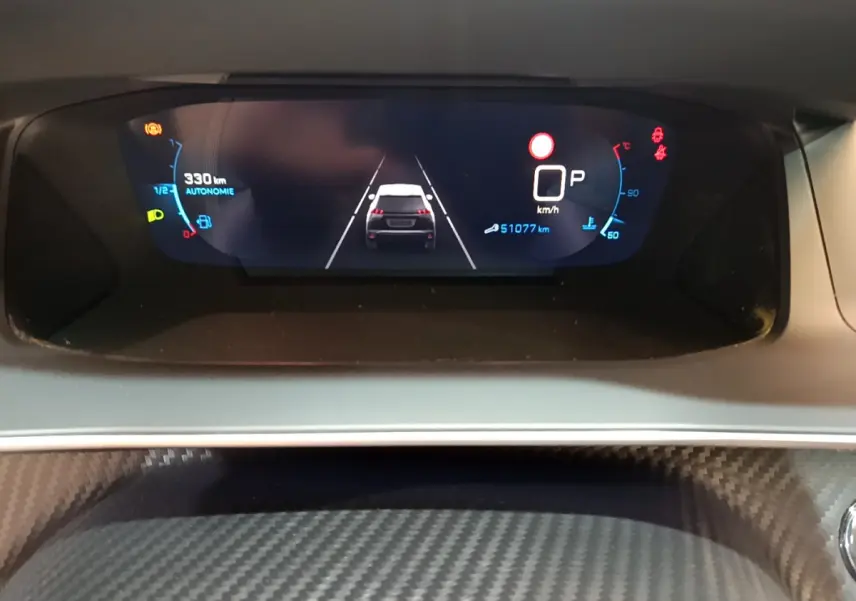 Affichage numérique du tableau de bord du Peugeot 2008 gris clair, montrant la vitesse à 0 km/h et l'autonomie restante.